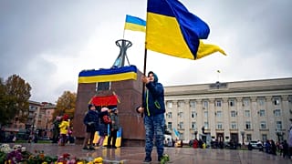 A boy holds a Ukrainian flag in central Kherson. 