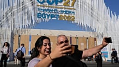 Two people take selfies at the COP27 UN Climate Summit.