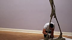 A sculpture "L'Homme qui marche" (2ndR) by Swiss artist Alberto Giacometti is prepared by an employee of the Pablo Picasso Museum in Muenster