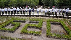 G20 Leaders raise their garden hoes for a group photo during a tree planting event at the Taman Hutan Raya Ngurah Rai Mangrove Forest