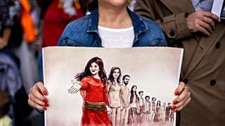 متظاهرة تحمل صورة الإيرانية مهساء أميني، خلال مسيرة لدعم المتظاهرين في إيران  - باريس. 2022/10/29