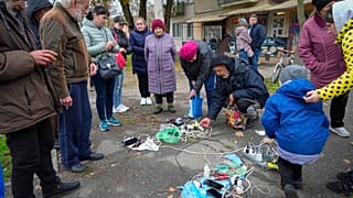 Κάτοικοι της Χερσώνας προσπαθούν να φορτίσουν τα τηλέφωνά τους