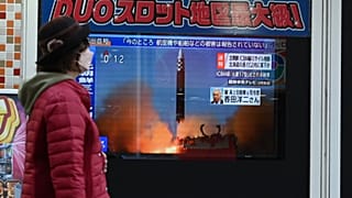 Une femme devant les actualités à Tokyo (Japon), le 18 novembre 2022.