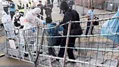 Migrants leave the Ocean Viking in Toulon on November 11, 2022, after being rescued by European maritime-humanitarian organization "SOS Mediterranee".