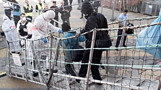 Migrants leave the Ocean Viking in Toulon on November 11, 2022, after being rescued by European maritime-humanitarian organization "SOS Mediterranee".