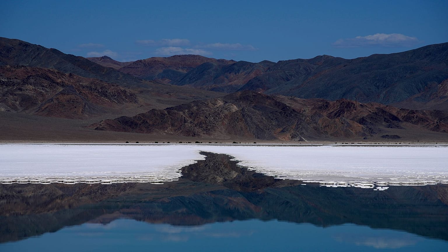 Mountains are reflected in a brine evaporation pond at Albemarle Corp.'s Silver Peak lithium facility, Thursday, Oct. 6, 2022