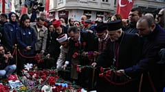 Representatives of the Turkish communities put flowers over a memorial placed on the spot of Sunday's explosion on Istanbul's popular pedestrian Istiklal Avenue in Istanbul, T