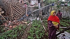 A woman walks past a house damaged by an earthquake in Cianjur, West Java, Indonesia, Monday, Nov. 21, 2022.