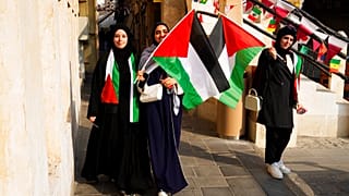 نساء فلسطينيات يلوحن بالعلم الفلسطيني قبل انطلاق كأس العالم لكرة القدم في الدوحة، قطر، السبت 19 نوفمبر 2022
