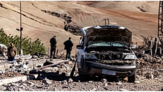 مواطنون يتفقدون موقعاً دمرته الغارات الجوية التركية التي استهدفت محطة كهرباء في قرية تاقل في محافظة الحسكة السورية