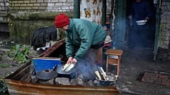 Eine Frau in Lyman in der Region Donezk bereitet am 15. November 2022 eine Mahlzeit zu