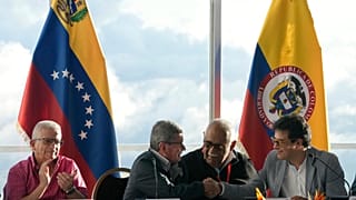 Miembros de las delegaciones del Gobierno colombia y de la guerrilla del ELN estrechan manos en la primera rueda de prensa tras primer encuentro en el hotel Humbold en Caracas