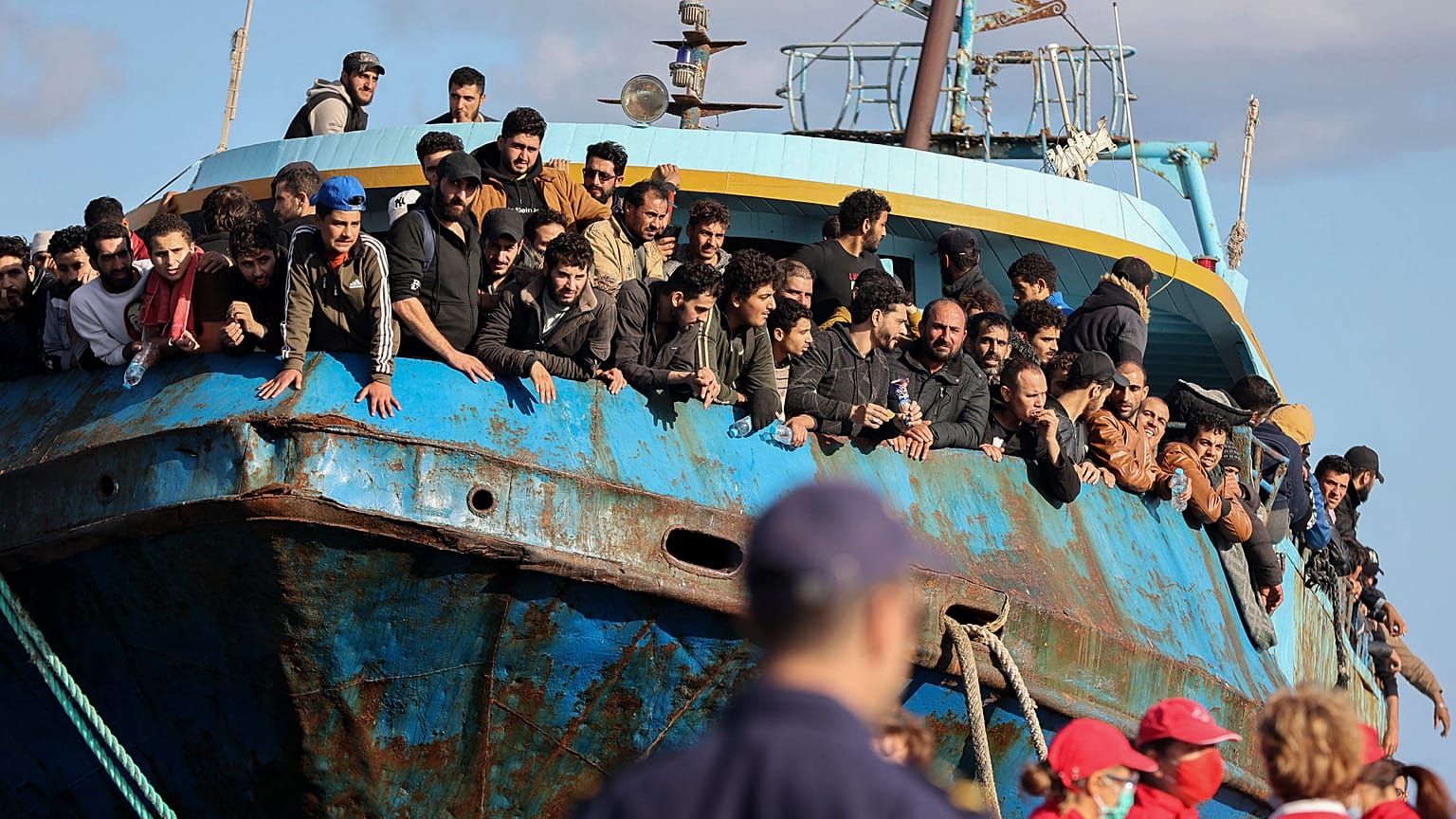 Migranten schauen aus einem Fischerboot, das im Hafen von Palaiochora im Südosten Kretas angedockt hat. 22. 11. 2022