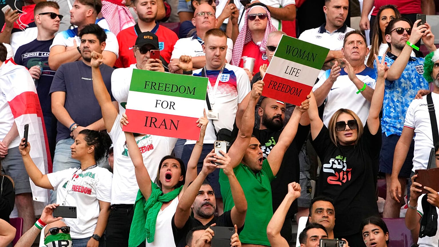 Iranian soccer fans hold up signs reading Woman Life Freedom and Freedom For Iran, at the Khalifa International Stadium in in Doha, Qatar, Monday, Nov. 21, 2022.