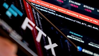 This photo illustration shows a message reading “We strongly advise against depositing” on the website of cryptocurrency FTX