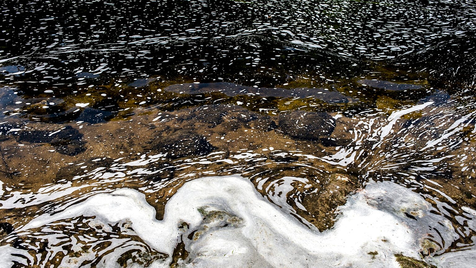 PFAS foam gathers at the the Van Etten Creek dam in Oscoda Township, Mich., near Wurtsmith Air Force Base, US. 