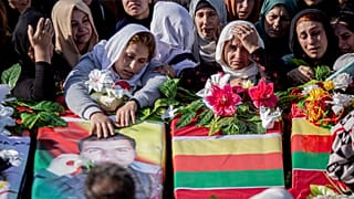 Syrian Kurds attend a funeral of people killed in Turkish airstrikes in the village of Al Malikiyah, northern Syria,