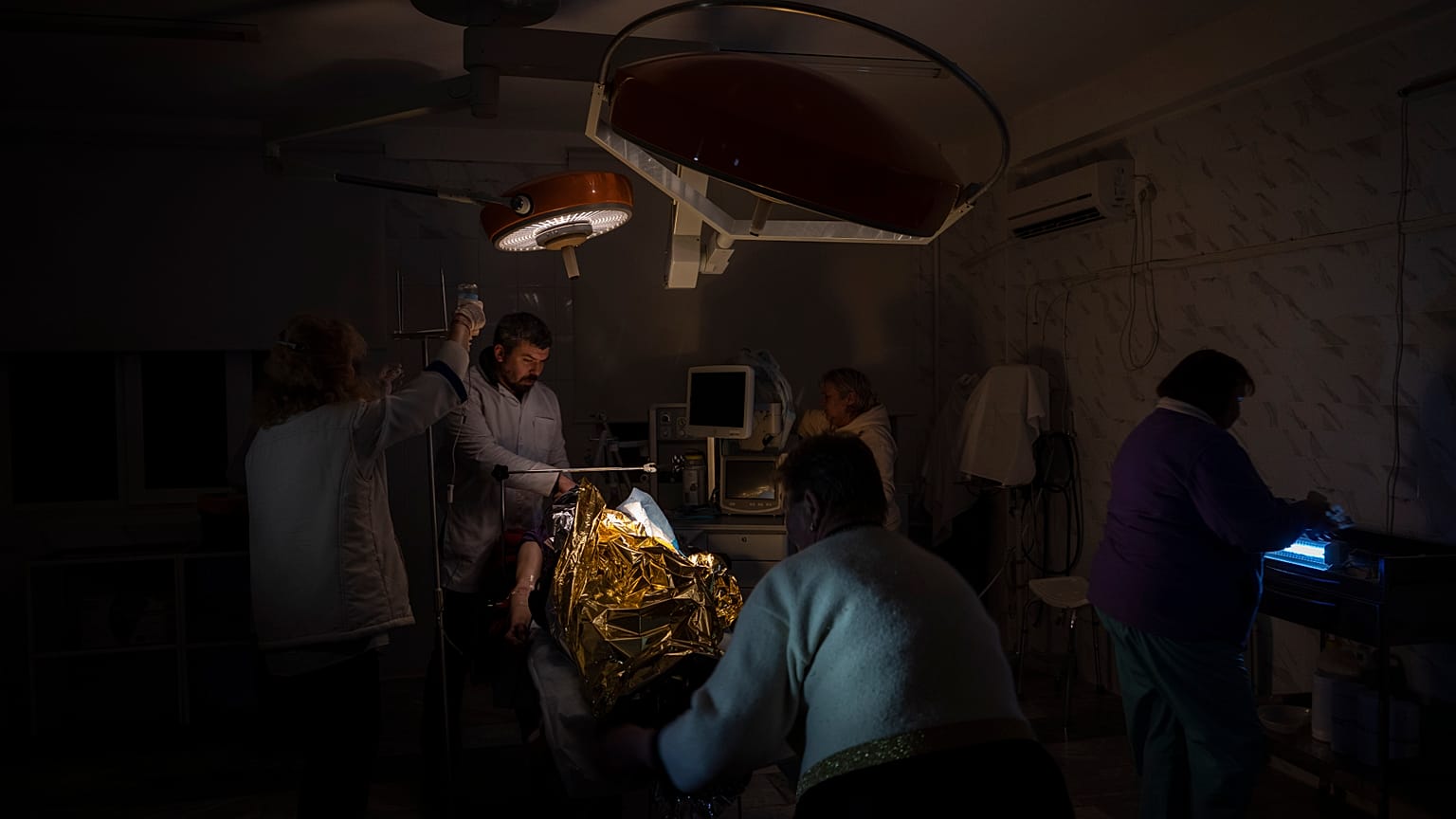 Des médecins opèrent un garçon de 13 ans blessé lors d'un bombardement dans un hôpital plongé dans le noir ou presque et avec très peu d'eau à Kherson, le 22 novembre 2022