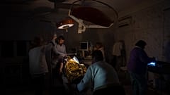 Des médecins opèrent un garçon de 13 ans blessé lors d'un bombardement dans un hôpital plongé dans le noir ou presque et avec très peu d'eau à Kherson, le 22 novembre 2022