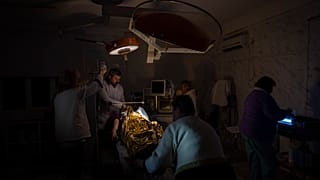 Des médecins opèrent un garçon de 13 ans blessé lors d'un bombardement dans un hôpital plongé dans le noir ou presque et avec très peu d'eau à Kherson, le 22 novembre 2022