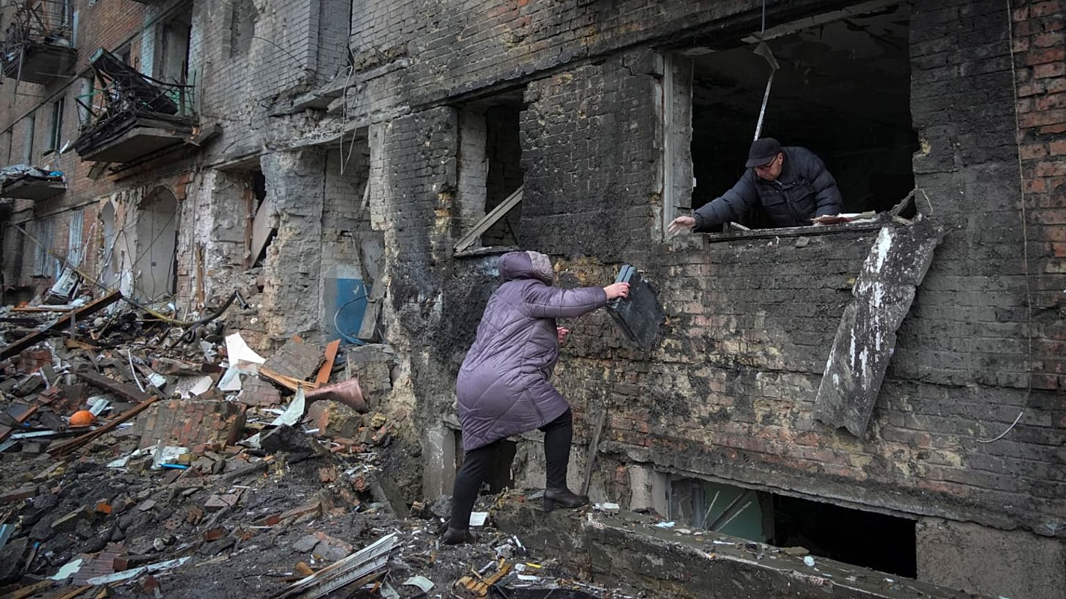 People gather their belongings from a damaged house in the town of Vyshgorod.