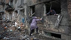 People gather their belongings from a damaged house in the town of Vyshgorod.