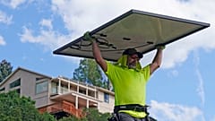 Phil Snow, of Power Shift Solar, installs a solar panel at a home in Salt Lake City.