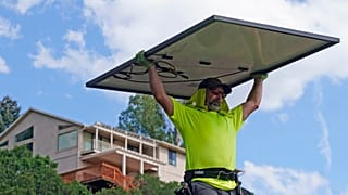 Phil Snow, of Power Shift Solar, installs a solar panel at a home in Salt Lake City.