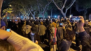 Residents record the scene as they mourn for the victims a recent deadly fire at a residential building in Urumqi city and calls for press freedom in Shanghai, Nov. 26, 2022.