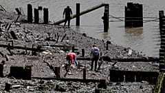 Mudlarks bei der Ausübung ihres Hobbys am Themse-Ufer in London