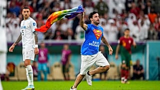 A pitch invader runs across the field with a rainbow flag during the World Cup match between Portugal and Uruguay, at the Lusail Stadium in Lusail, Qatar, 28 October.