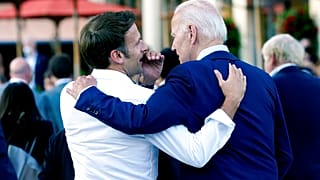 Macron whispers to U.S. President Joe Biden following their dinner at the G7 Summit in Elmau, Germany, June 26, 2022.
