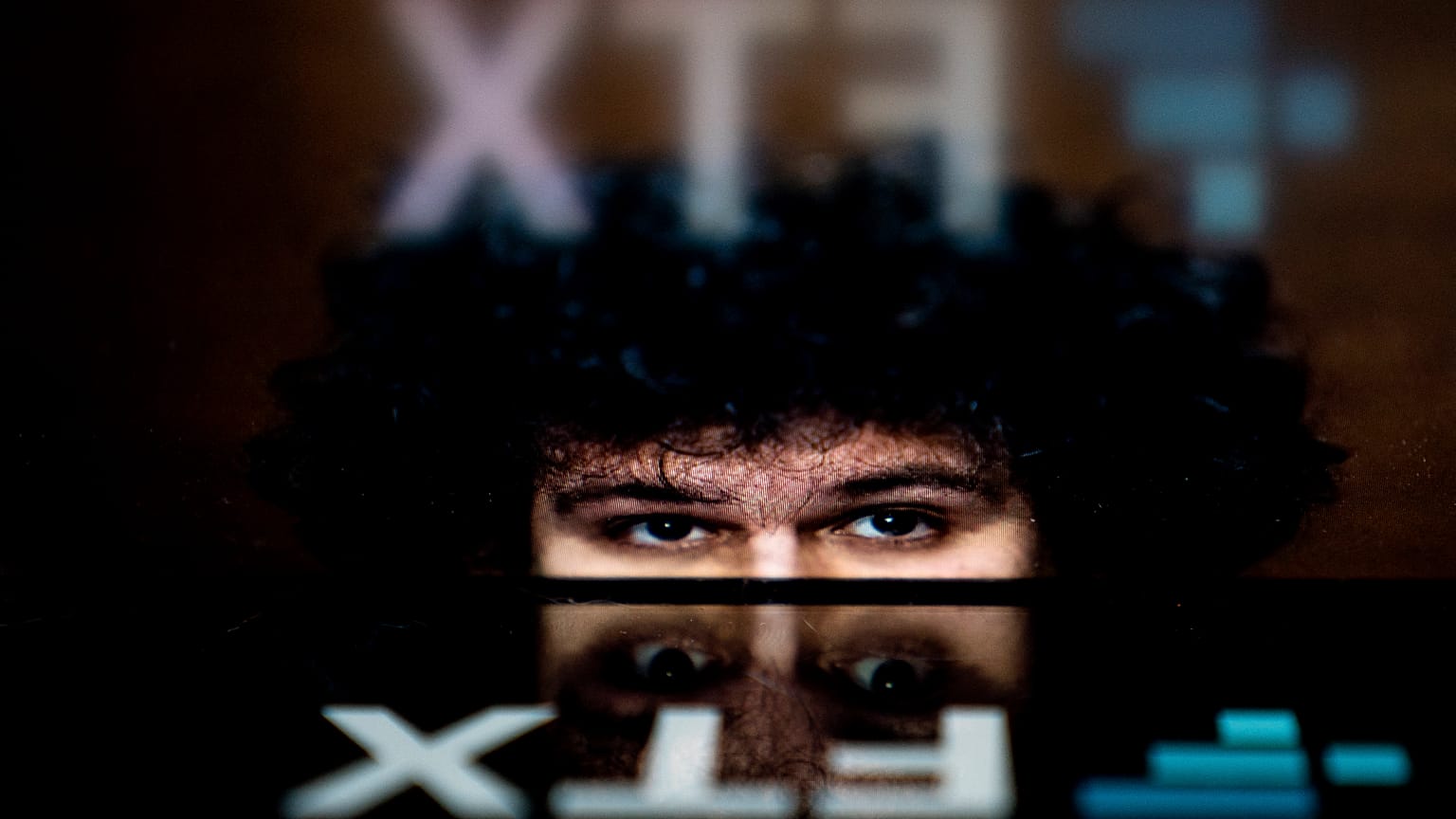 In this file photo illustration taken on November 13, 2022, shows the logo of cryptocurrency FTX, reflected in an image of former chief executive Samuel Bankman-Fried