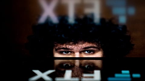 In this file photo illustration taken on November 13, 2022, shows the logo of cryptocurrency FTX, reflected in an image of former chief executive Samuel Bankman-Fried
