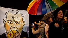  Protesters take photos of a poster depicting the leader of Poland's Law and Justice party, Jaroslaw Kaczynski, on Monday.