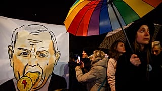 Protesters take photos of a poster depicting the leader of Poland's Law and Justice party, Jaroslaw Kaczynski, on Monday.