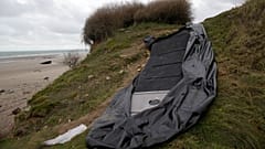 A damaged inflatable small boat is pictured on the shore in Wimereux, northern France.