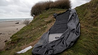A damaged inflatable small boat is pictured on the shore in Wimereux, northern France.