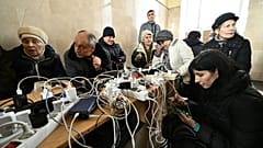Des habitants de Kherson rechargent leur téléphone à la gare de la ville, l'un des rares bâtiments à disposer de l'électricité.