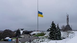 The Ukrainian flag flatters at half mast near the Ukrainian Motherland monument in Kyiv, Ukraine