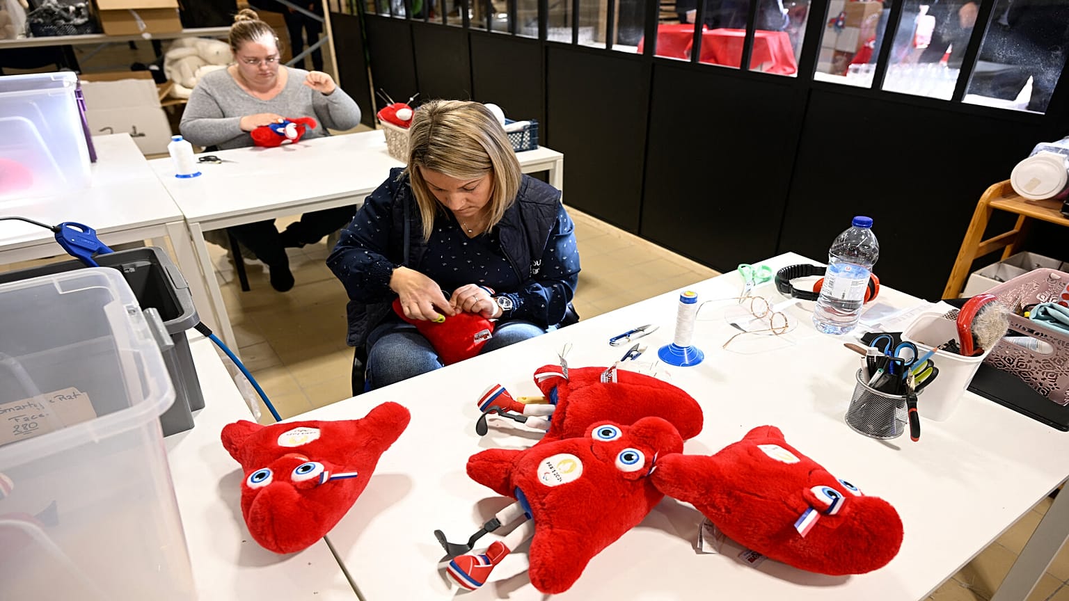 Des employés fabriquent des peluches représentant la mascotte "Phryges" des Jeux olympiques et paralympiques de Paris 2024 dans l'atelier de Doudou et Compagnie