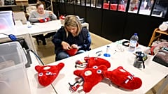 Des employés fabriquent des peluches représentant la mascotte "Phryges" des Jeux olympiques et paralympiques de Paris 2024 dans l'atelier de Doudou et Compagnie