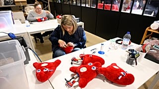 Des employés fabriquent des peluches représentant la mascotte "Phryges" des Jeux olympiques et paralympiques de Paris 2024 dans l'atelier de Doudou et Compagnie