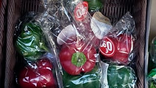 Peppers wrapped in plastic package are on display on a grocery stall in Paris, Friday, Dec. 31, 2021.
