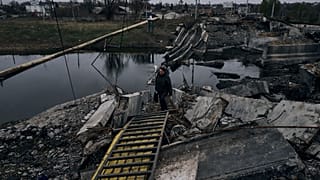 Una mujer camina por un puente explotado en Bajmut, Ucrania, región de Donetsk, Ucrania, el viernes 11 de noviembre de 2022.