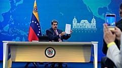 El presidente venezolano Nicolás Maduro sostiene un documento relacionado con el reinicio de las conversaciones entre su gobierno y la oposición, el 30 de noviembre de 2022.