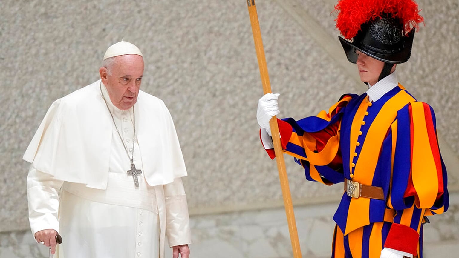 Pope Francis walks past a Swiss Guard as he arrives to meet with members of the Italian Schools for Peace Network at the Vatican, Monday, Nov. 28, 2022.
