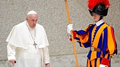 Pope Francis walks past a Swiss Guard as he arrives to meet with members of the Italian Schools for Peace Network at the Vatican, Monday, Nov. 28, 2022.
