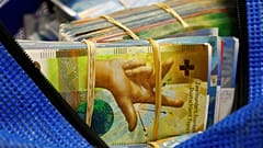 Bundles of unsorted Swiss franc banknotes lie in a transport bag at a Swiss bank in Zurich.