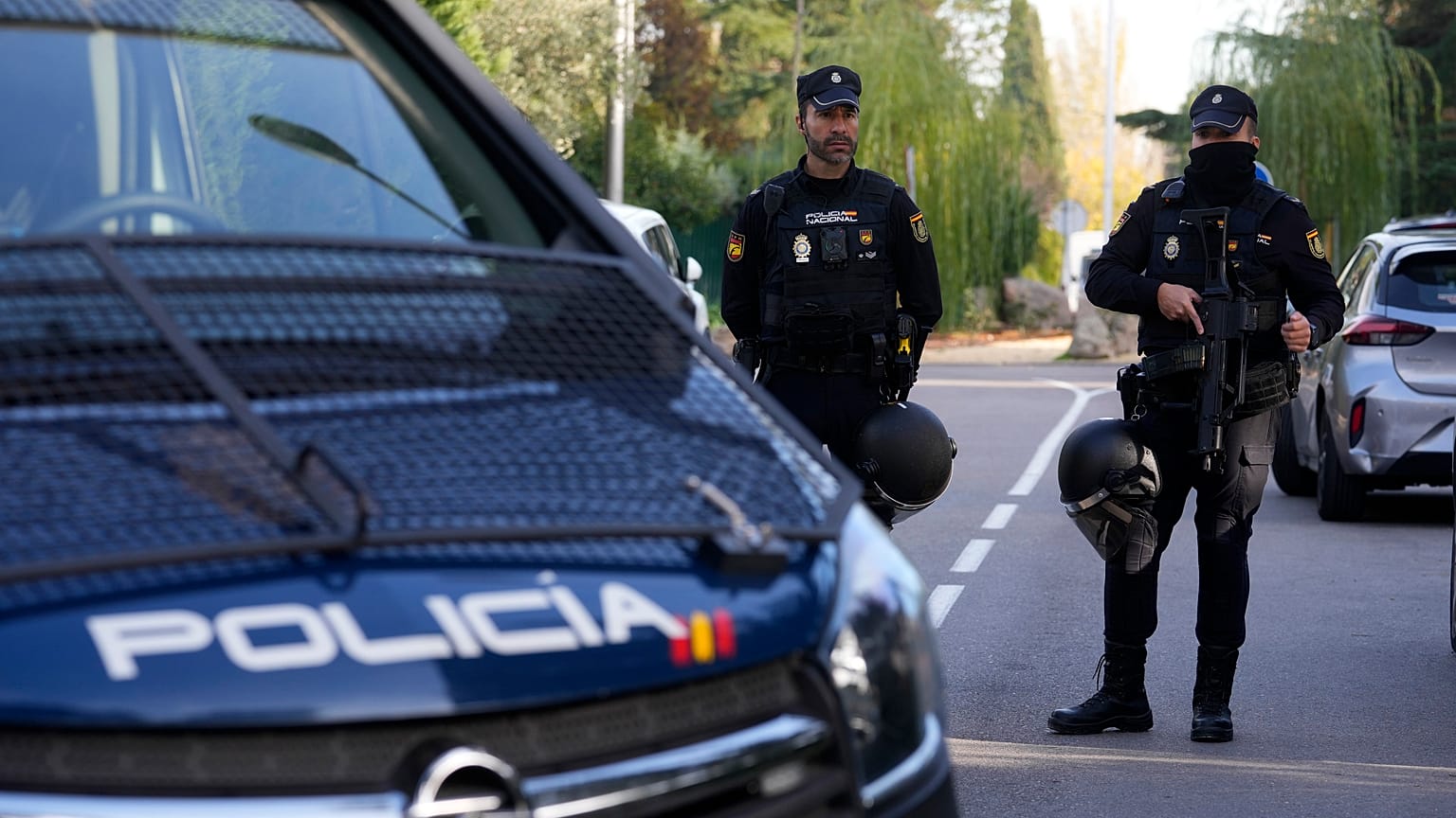 Police officers stand guard as other officers in yellow vests walk back at the cordoned off area next to the Ukrainian embassy in Madrid, Spain, Wednesday, Nov. 30, 2022. 